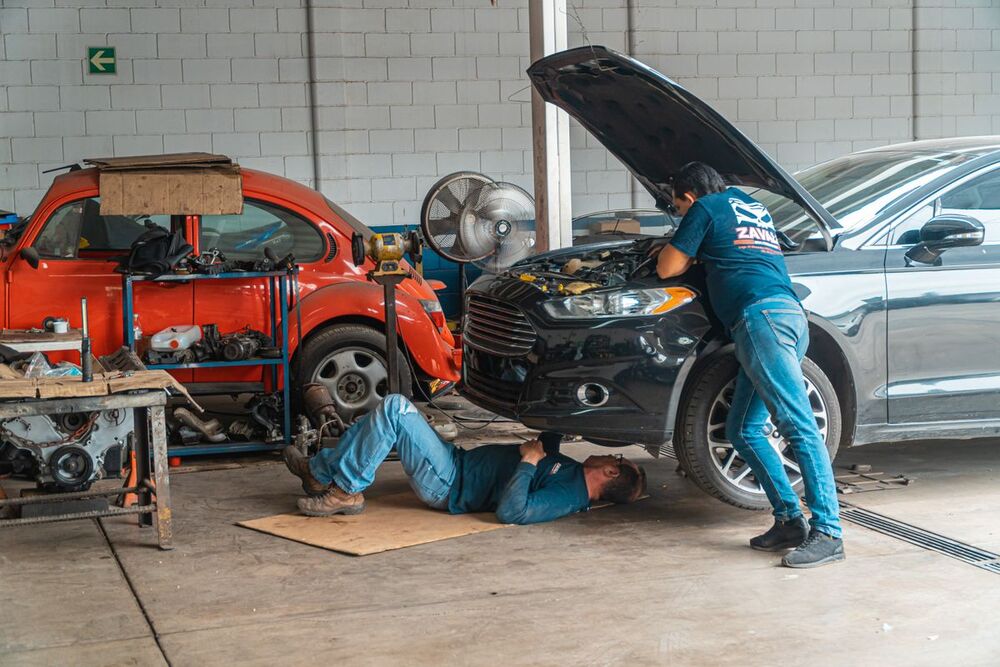 Mecánicos reparando coches en un taller