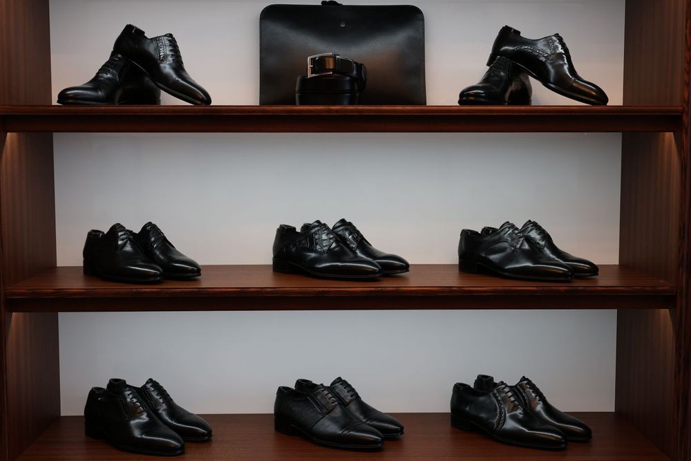 Zapatos de piel en estanterías de madera